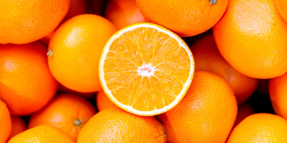 Los perros pueden comer naranja Descubrí si los perros pueden comer naranja. Frutas enteras juntas con una rodaja en el centro.