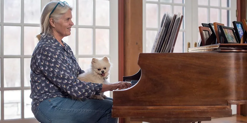 Uno de los beneficios de tener un perro es que genera compañía, como a esta mujer que toca el piano.